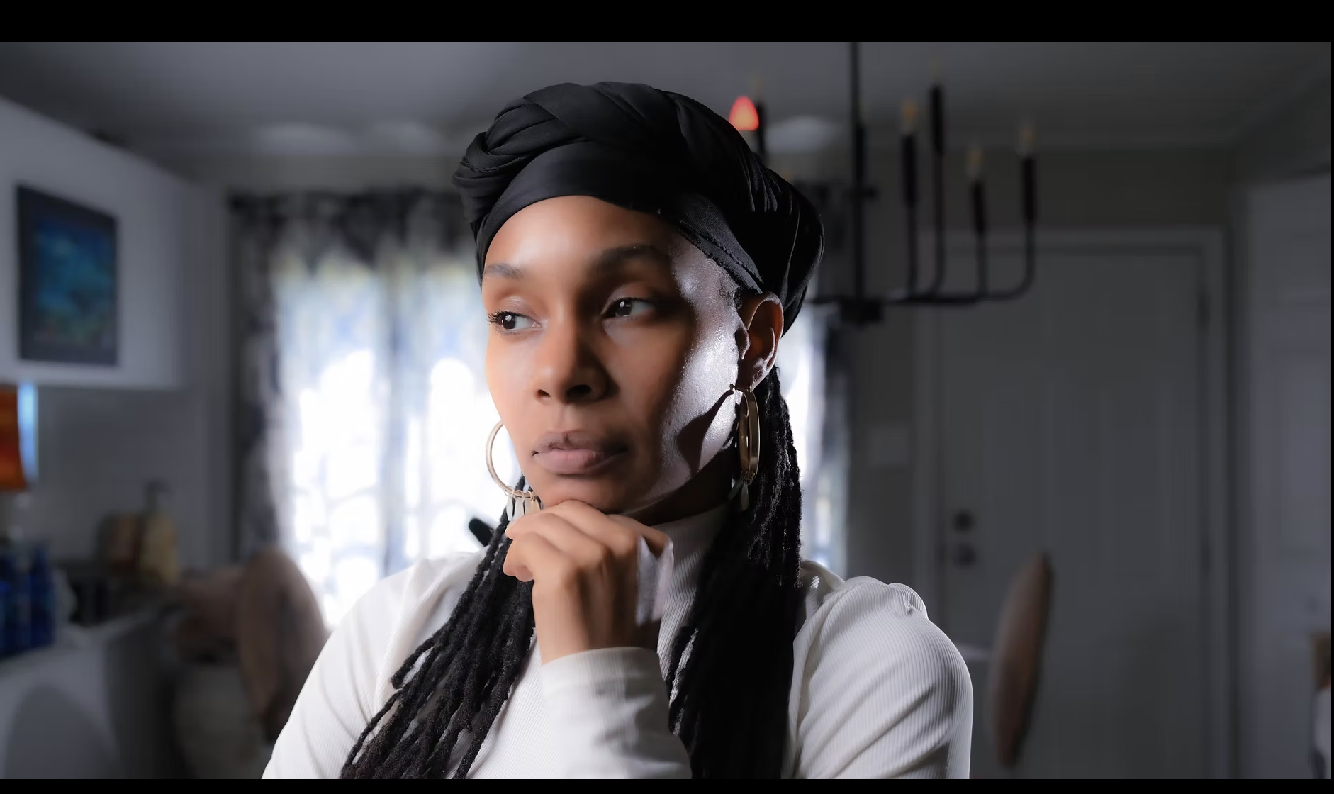 Nikki Brianne standing outdoors in Alaska with camera gear, showcasing her work in filmmaking, photography, and holistic loc care.